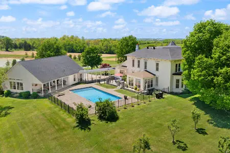 Aerial View showing main home, inground pool and pool house with 3 car garage